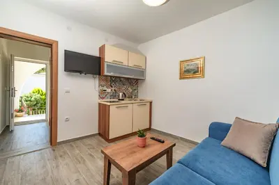 a living room with a blue couch and a table at Mika's Seaview Apartments in Bar