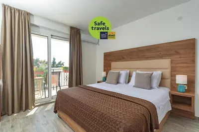 a bedroom with a large bed and a balcony at Mika's Seaview Apartments in Bar