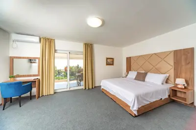 a bedroom with a bed and a desk and a window at Mika's Seaview Apartments in Bar
