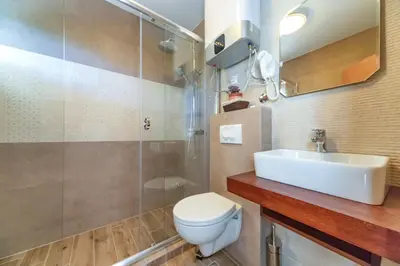 a bathroom with a toilet and a sink and a shower at Mika's Seaview Apartments in Bar