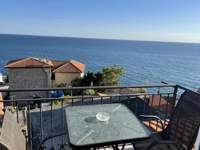 a table and chairs on a balcony overlooking the ocean at Apartments Kalaja in Ulcinj