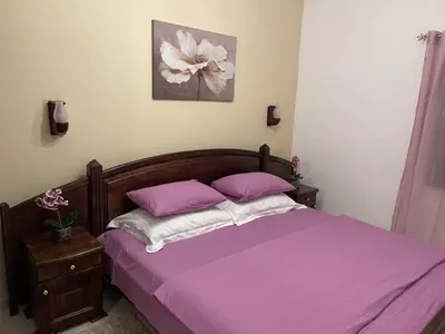 a bed with purple sheets and pillows in a bedroom at Apartments Kalaja in Ulcinj