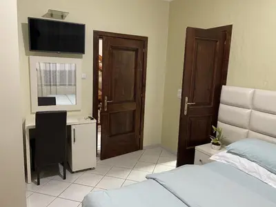 a bedroom with a bed and a desk and a television at Apartments Kalaja in Ulcinj