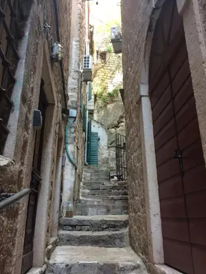 an alley between two buildings with stairs and a door at Chic & Stylish with Seaview-Terrace - Kotor Indah in Kotor