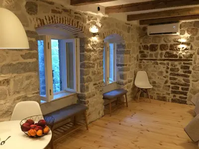 a room with stone walls and windows and a table and chairs at Chic & Stylish with Seaview-Terrace - Kotor Indah in Kotor