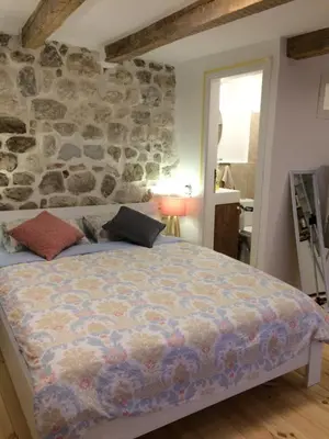 a bedroom with a bed with a stone wall at Chic & Stylish with Seaview-Terrace - Kotor Indah in Kotor