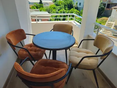 a balcony with a blue table and chairs at Apartmani Nilaj in Ulcinj