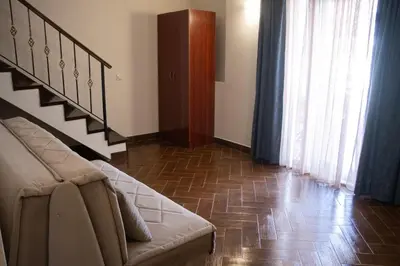a living room with a couch and a staircase at Apartmani Nilaj in Ulcinj