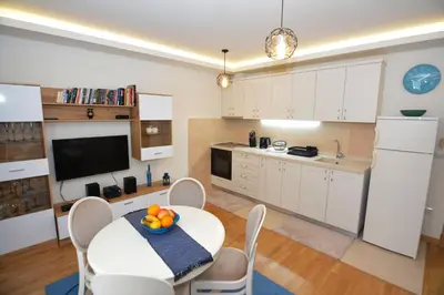 a kitchen and dining room with a table and chairs at Apartments Olive in Kotor