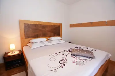 a bedroom with a bed with a white blanket and a purse at Apartments Olive in Kotor