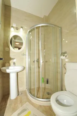 a bathroom with a shower and a toilet and a sink at Apartments Olive in Kotor