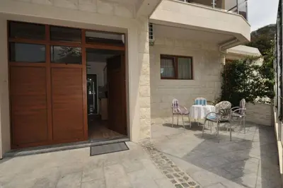 a house with a wooden door with a table and chairs at Apartments Olive in Kotor
