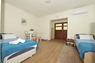 a bedroom with two beds and a table with a table at Apartments Olive in Kotor