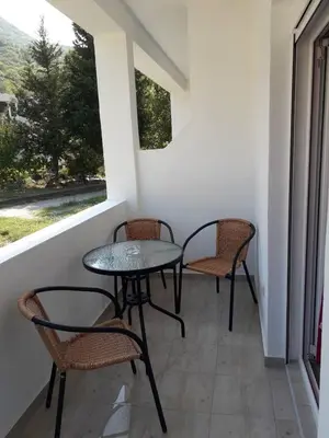 a patio with two chairs and a table and a window at Apartmani Andrea-jaz in Budva