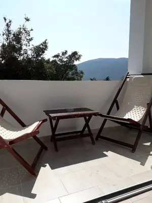 two chairs and a wooden table on a patio at Apartmani Andrea-jaz in Budva