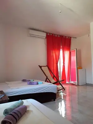 a bedroom with two beds and a red curtain at Apartmani Andrea-jaz in Budva