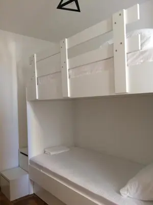 a room with white bunk beds in it at Apartman Tijana in Budva