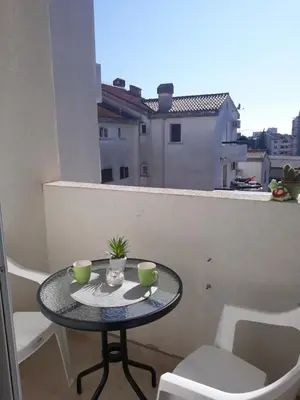 a small table with two cups on a balcony at Apartman Tijana in Budva