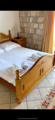 a bedroom with a wooden bed with towels on it at Apartments Amina in Ulcinj