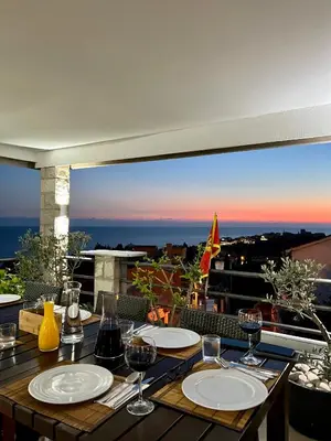 a table with plates and wine glasses on a balcony at Apartments Amina in Ulcinj