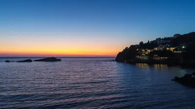 a sunset over a body of water with a city at Apartments Eneida in Ulcinj