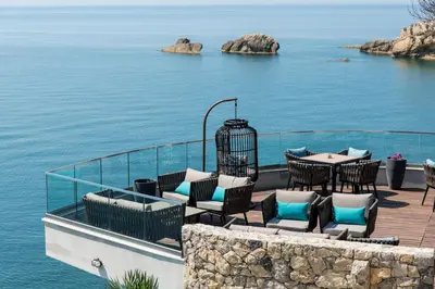 a deck with a table and chairs and the ocean at Apartments Eneida in Ulcinj