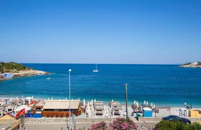 a beach with a bunch of chairs and the ocean at Apartments Oliva in Utjeha