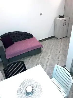 a room with a bed and a table and chairs at Flat Una in Budva