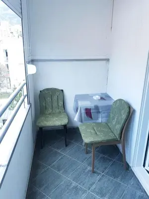 two chairs and a table in a room with a window at Flat Una in Budva