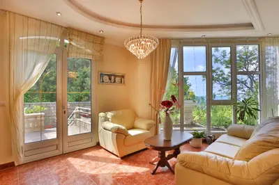 a living room with two couches and a table at Royal Holiday Apartments Sveti Stefan in Sveti Stefan