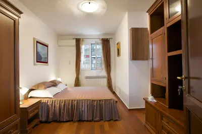 a bedroom with a bed and a window at Royal Holiday Apartments Sveti Stefan in Sveti Stefan
