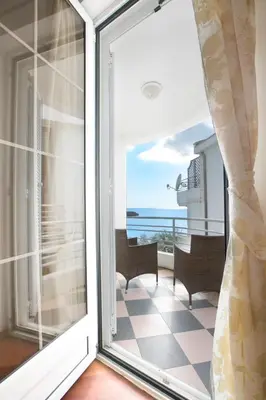 a sliding glass door with a view of the ocean at Royal Holiday Apartments Sveti Stefan in Sveti Stefan