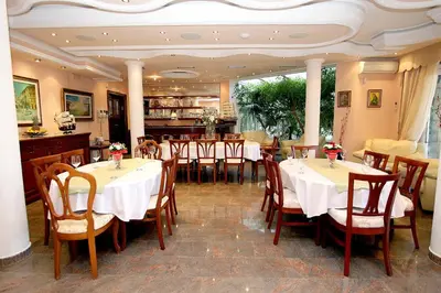 a restaurant with tables and chairs in a room at Royal Holiday Apartments Sveti Stefan in Sveti Stefan