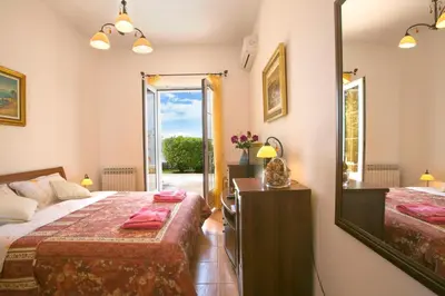 a bedroom with two beds and a mirror at Royal Holiday Apartments Sveti Stefan in Sveti Stefan