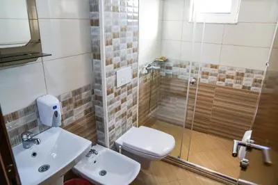 a bathroom with a toilet and a sink and a shower at Apart Hotel Llolla in Ulcinj