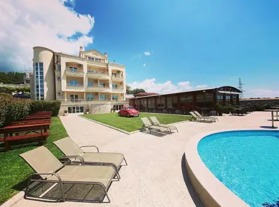a swimming pool with chairs and a building at Apart Hotel Llolla in Ulcinj