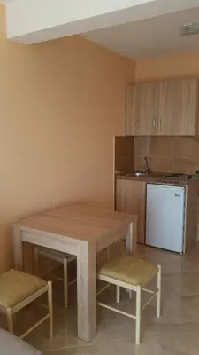 a kitchen with a wooden table and two chairs at Apartments Popovic in Ulcinj