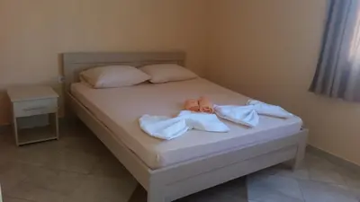 a bed with two pairs of flip flops on it at Apartments Popovic in Ulcinj