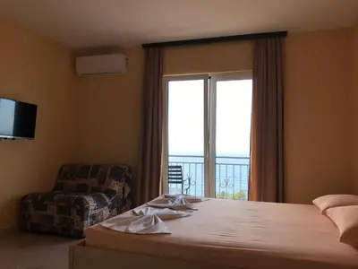 a bedroom with a bed and a window and a chair at Apartments Popovic in Ulcinj