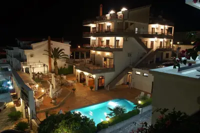 a view of a building with a swimming pool at night at Hotel Kleopatra in Ulcinj