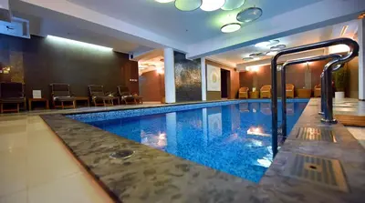 a swimming pool in a hotel room with chairs at Hotel Ziya in Podgorica