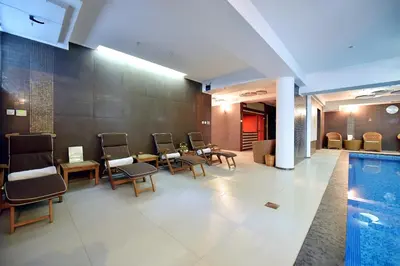 a lobby with a pool and tables and chairs at Hotel Ziya in Podgorica