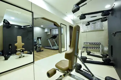 a salon with a mirror and a gym at Hotel Ziya in Podgorica