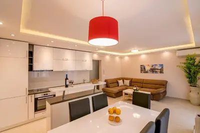 a kitchen and living room with a table and a couch at Apartmani Matej in Kotor