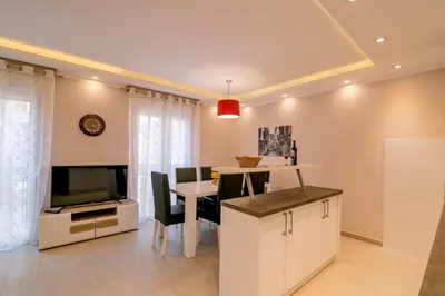 a kitchen and dining room with a table and a television at Apartmani Matej in Kotor