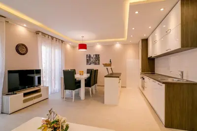 a kitchen and dining room with a table and a television at Apartmani Matej in Kotor