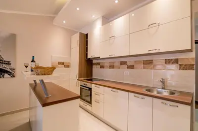 a kitchen with white cabinets and a sink at Apartmani Matej in Kotor