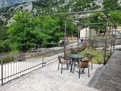a patio with a table and chairs and a fence at Apartment Marta in Kotor
