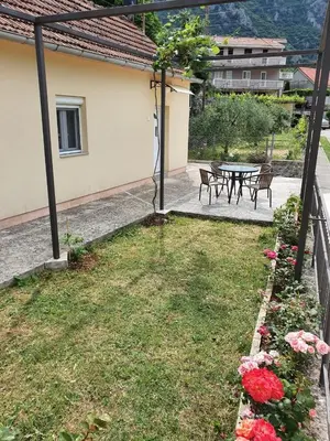 a backyard with a table and chairs and flowers at Apartment Marta in Kotor