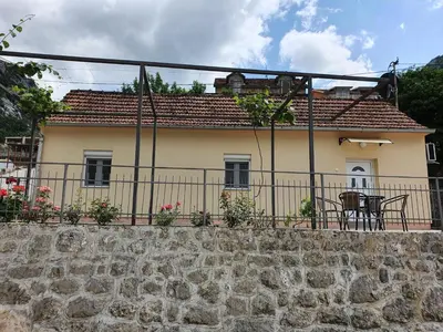 a house with a table and chairs on a fence at Apartment Marta in Kotor